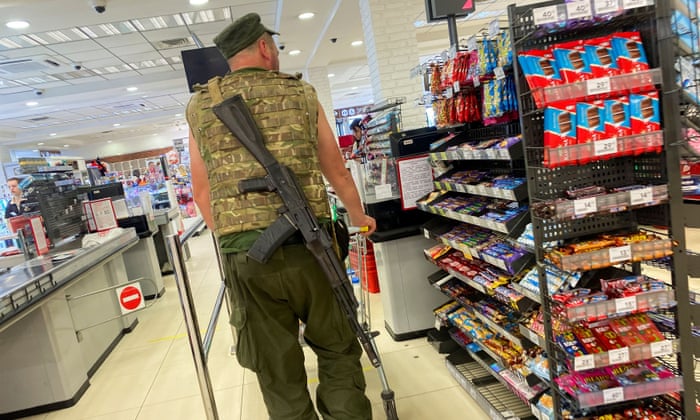 A Ukrainian serviceman pushes a trolley inside a supermarket in Kharkiv.