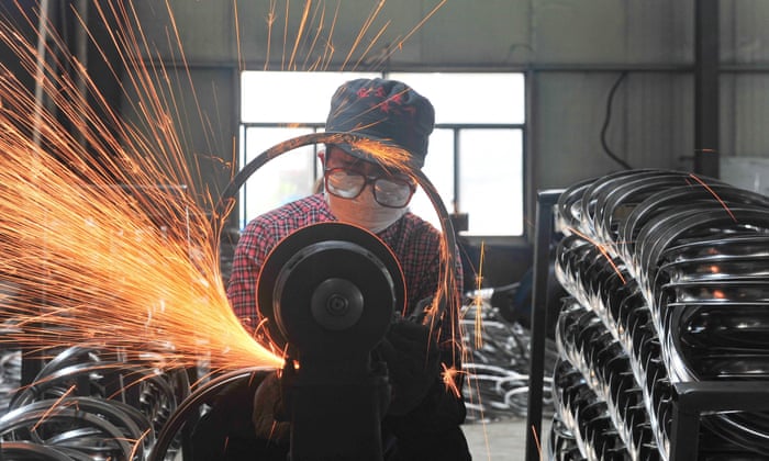 This photo taken on April 17, 2022 shows a worker welding wheels at a factory in Hangzhou in China's eastern Zhejiang province. 