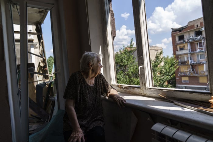 Ida Svystunova, 89, looks out the damaged room adjoining her apartment. Svystunova is one of only four people left living in the block and spends most of her day looking out the window. “I sit and wait for the end of this war or maybe the end of ourselves,” she said.